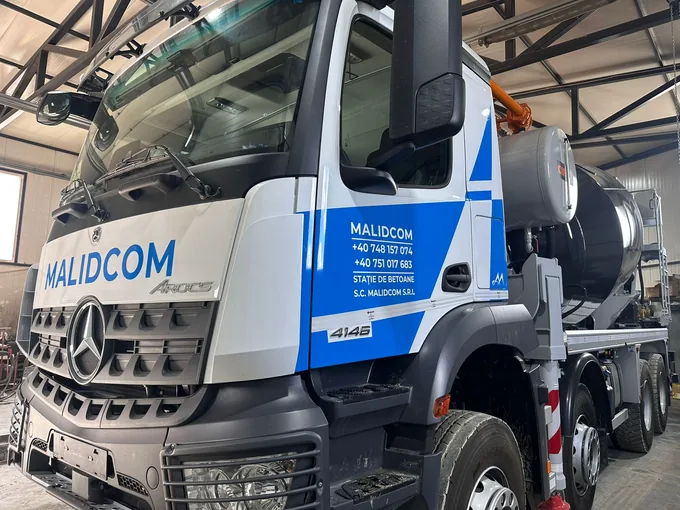 Detaliu al cabinei Mercedes Arocs cu inscripționare Malidcom și grafică albastră