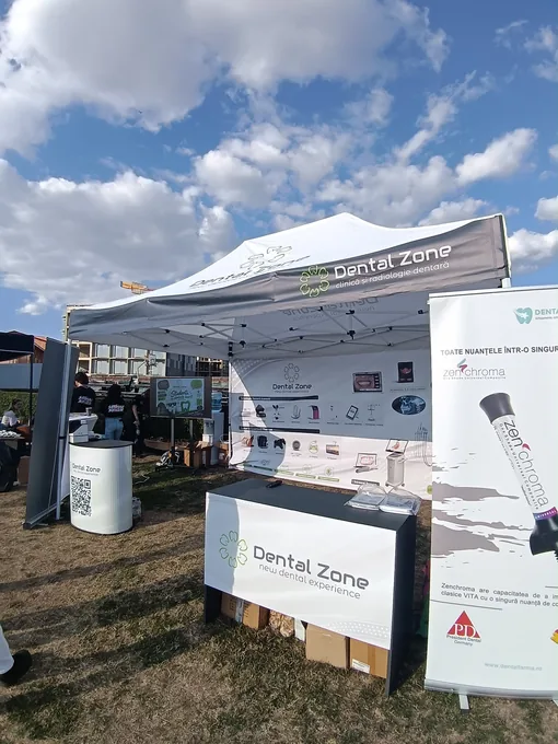 Cort Dental Zone cu panou de fundal, tejghea și roll-up la un eveniment
